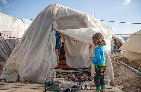 یک کودک از قربانیان زلزله در کنار چادر محل زندگیش